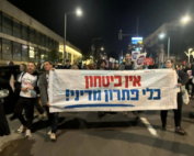 Peace Now activists march with thousands in weekly protests in Tel Aviv. The banner reads: "There's no security without a political solution."